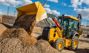 A 410L Backhoe unloads dirt and gravel