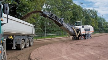 Milling off the surface of a cinder football pitch.